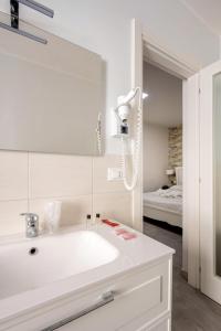 Un baño blanco con lavabo y espejo. en Porta Nazionale Dependance, en Noto 58 fotos más