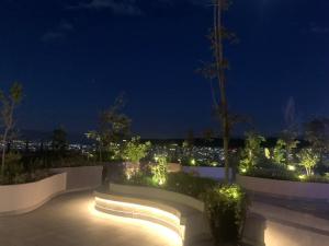 a garden with a bench and lights at night at Espectacular departamento con vista a la Carolina con Generador de luz in Quito