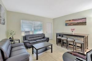 uma sala de estar com um sofá e uma mesa em 2bd cottage style, pets, parking (315E) em Delray Beach