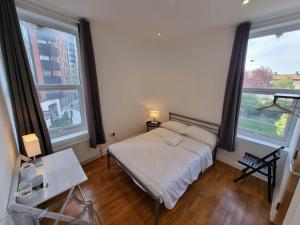 a small bedroom with a bed and two windows at Horangee Pocha in London
