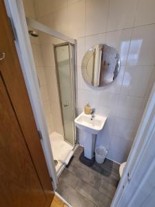 a small bathroom with a sink and a mirror at Horangee Pocha in London