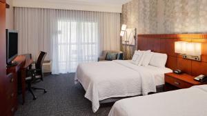 a hotel room with two beds and a desk at Courtyard by Marriott Pittsburgh West Homestead Waterfront in West Homestead