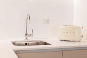 a toaster sitting on a kitchen counter next to a sink at Beautiful apartment 4P1BR Parc Montsouris in Paris