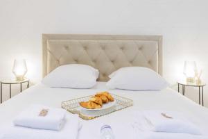 ein Tablett mit Croissants auf einem Bett mit einem Teller Essen in der Unterkunft Beautiful apartment 4P1BR Parc Montsouris in Paris