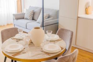 einem Esstisch mit Tellern und einer Vase darauf in der Unterkunft Beautiful apartment 4P1BR Parc Montsouris in Paris