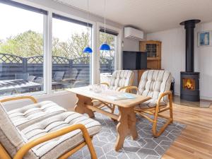 een woonkamer met een tafel en stoelen en een open haard bij 4 person holiday home in L kken in Løkken