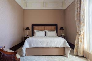 a bedroom with a bed with white sheets and pillows at Anantara Palazzo Naiadi in Rome