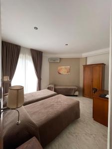 une chambre d'hôtel avec deux lits et un canapé dans l'établissement Il Castello, à Terzigno