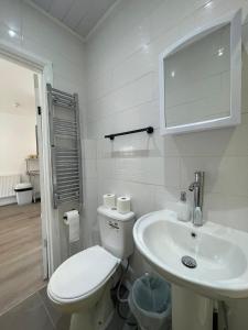 Baño blanco con aseo y lavamanos en Araan House Hotel -Families and Couples Only en Blackpool