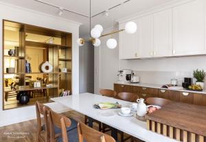 Mariacka Residence في غدانسك: مطبخ وغرفة طعام مع طاولة وكراسي