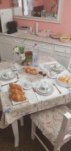 een tafel met croissants en borden met eten erop bij Villa Ferrari Oriella in Solignano Nuovo