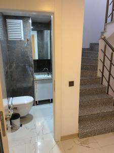 a bathroom with a toilet and a sink and a staircase at pointrezidans in Ankara