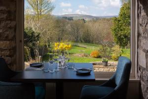 a table with a view of a garden from a window at Aysgarth Falls Hotel & Restaurant in Aysgarth