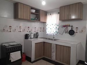 a kitchen with a sink and a stove in it at Gamtoos House:Lovely 3 Bedroom House in Naivasha