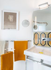 La salle de bains est pourvue d'un lavabo, d'un miroir et de serviettes. dans l'établissement Masseria Alchimia, à Fasano