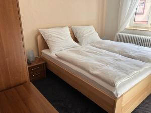 1 dormitorio con 1 cama con sábanas blancas y ventana en Apartmány Windy, en Ciudad Vieja de Praga