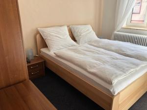 a bedroom with a bed with white sheets and a window at Apartmány Windy in Staré Město