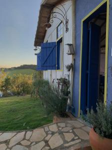 una casa azul y blanca con una puerta azul en Chalé Perto Do Céu, en São Thomé das Letras