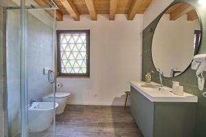 bagno con lavabo, servizi igienici e specchio di Casale San Pietro a Palmanova