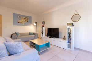 uma sala de estar com um sofá e uma televisão em Villa Roberto Ibiza em Sant Josep de sa Talaia