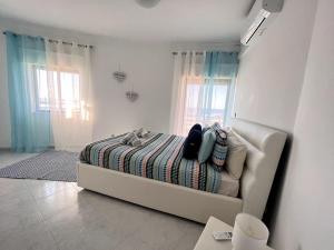 a white couch in a room with a bed at O mar na frente de lux Caparica in Costa da Caparica