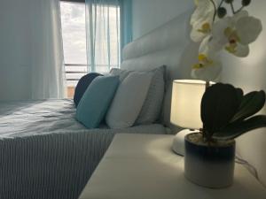 a bedroom with a bed and a table with a potted plant at O mar na frente de lux Caparica in Costa da Caparica