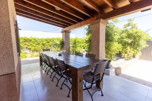 drewniany stół i krzesła na patio w obiekcie Villa Roberto Ibiza w mieście San Jose de sa Talaia