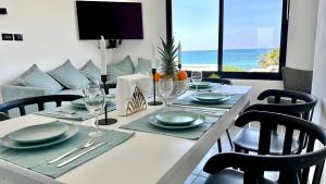 uma mesa de jantar com vista para o oceano em GW945 Gugel Waves Amazing Seaview Apartments em Nahariya