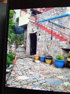 a stone walkway with potted plants in front of a building at Kastania..2 in Kiolianá