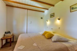 um quarto com uma cama grande e almofadas amarelas em Apartment Dolores em Roč