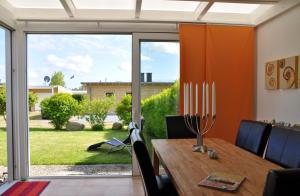 uma sala de jantar com uma mesa e uma grande porta de vidro deslizante em Marienleuchte MeerLUST em Westfehmarn