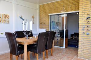 uma sala de jantar com uma mesa de madeira e cadeiras pretas em Marienleuchte MeerLUST em Westfehmarn