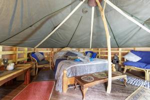 um quarto com uma cama numa tenda em Hobbity Bell Hobbity log burner - Hobbity stay em Canterbury