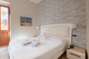 ノートにあるPorta Nazionale Dependanceのベッドルーム1室(白いベッド1台、タオル付)