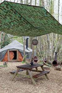 una tienda y una mesa de picnic de madera frente a una mesa de madera sidx sidx sidx sidx en Hobbity Bell Hobbity log burner - Hobbity stay, en Canterbury