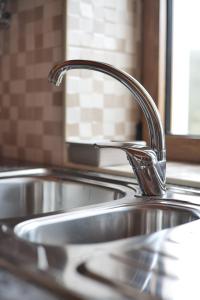 a stainless steel sink with a faucet in a kitchen at Recanto Da Ribeira Casas De Campo in Monchique +110 photos
