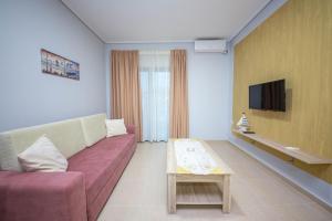 a living room with a couch and a tv at Mamma's Apartments in Sarandë