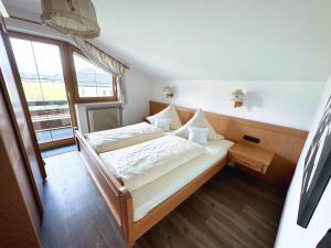 a bedroom with a bed and a large window at Haus Anna in Fischen