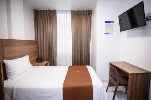 a bedroom with a bed and a desk and a television at Las Torres Hotel Boutique in Moquegua
