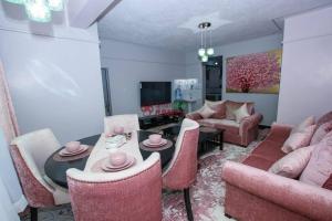 ナイバシャにあるPink Amur House.3 Bedroom Stylish & Epic.のソファとテーブルと椅子のあるリビングルーム