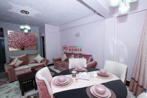 ナイバシャにあるPink Amur House.3 Bedroom Stylish & Epic.のテーブルと椅子のあるリビングルーム