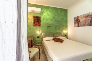 1 dormitorio con 2 camas y pared verde en Sogno d'Estate - Appartmento en Savona