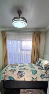 a bedroom with a large bed with a large window at Villa Dubaai in Mossel Bay