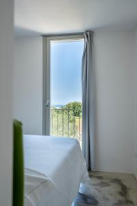 a bedroom with a bed and a large window at Masseria Alchimia in Fasano