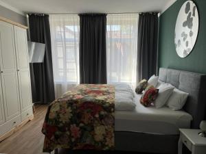 a bedroom with a bed with a floral bedspread at Studio 8 in Hameln +3 photos