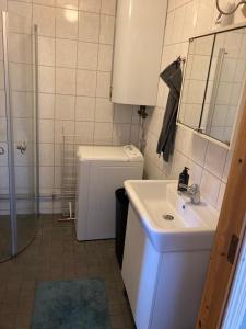 a bathroom with a sink and a toilet and a mirror at Fint boende i vackra Marielund in Uppsala