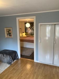 Habitación con dormitorio con cama y espejo. en Fint boende i vackra Marielund en Uppsala