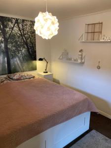 Un dormitorio con una cama grande y una lámpara de araña. en Fint boende i vackra Marielund en Uppsala