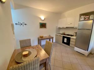 a kitchen and dining room with a table and a refrigerator at Leme Bedje - Pool, WiFi & Beachfront in Santa Maria