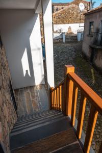 a stairway leading up to a building with a wooden railing at Casa das Ruas (Xisto Sentido®) 